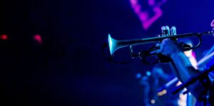 Close-up van een trompettist onder blauw en paars podiumlicht