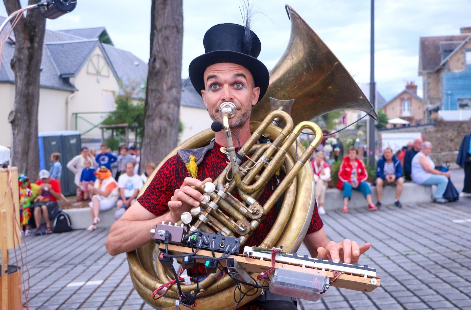 Straatmuzikant met koperen instrument en elektronica voor publiek
