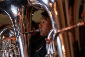 Blaasmuzikant speelt tuba tijdens een optreden tussen andere koperblazers