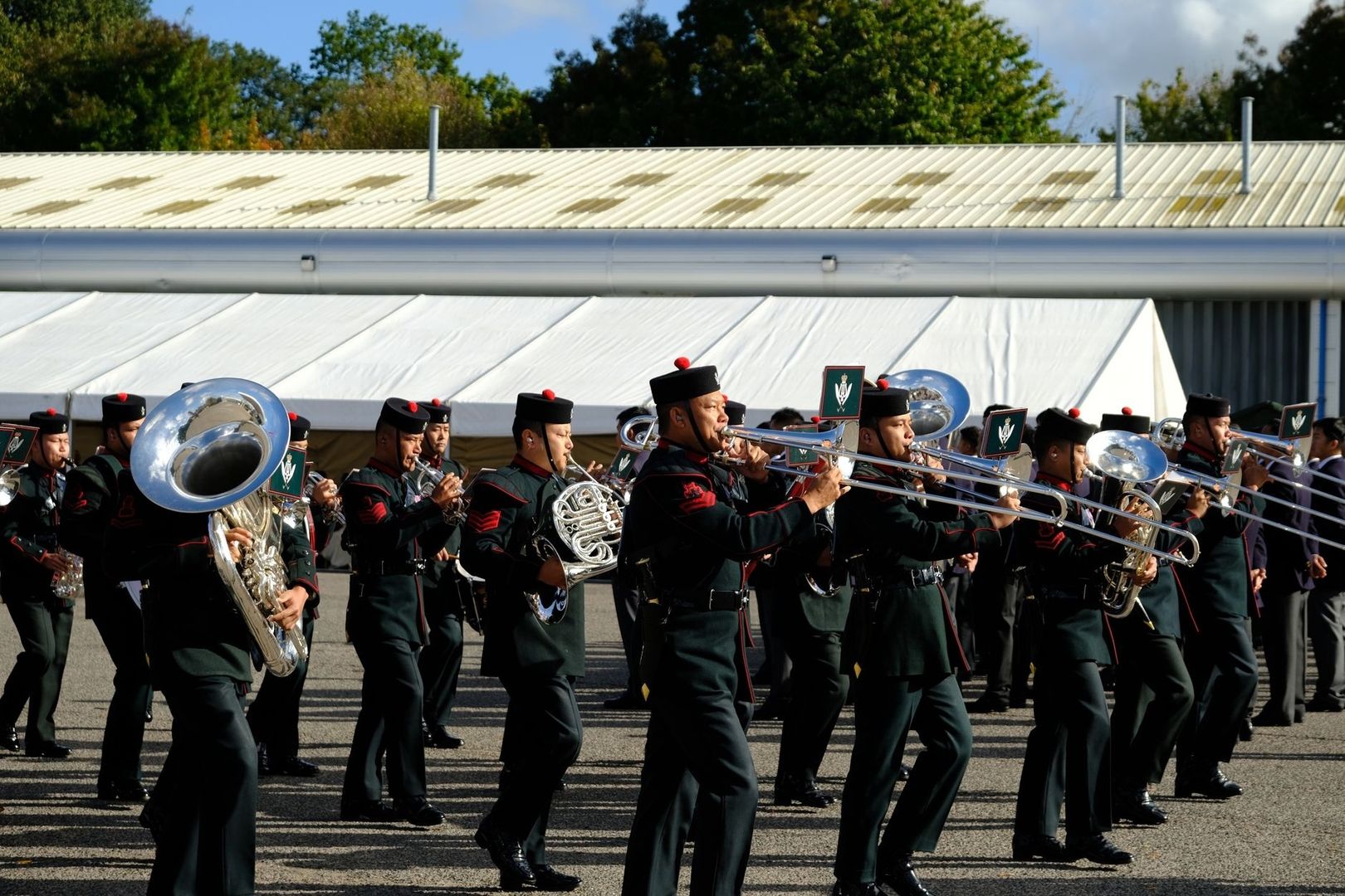 Marcherend blaasensemble speelt trombones en tuba